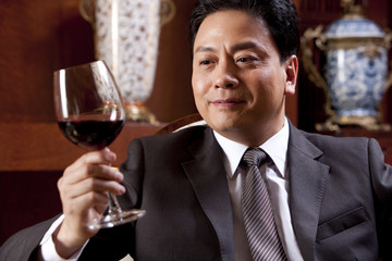 Mature businessman enjoying wine in a luxurious room