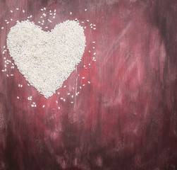 rice for risotto, lined heart, valentines day on wooden rustic background top view close up border,with text area