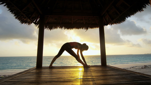 Girl in silhouette practicing yoga outdoor