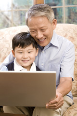 Grandfather and grandson using laptop