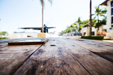 Selected empty wooden deck table with copy space and bokeh background at port