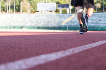 Blurry focus image of the man jogging in running track during knee pain