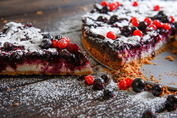 Piece of homemade berry cake on the wood background