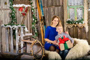 Obraz na płótnie Canvas Boy with a mother sitting on Christmas sleigh