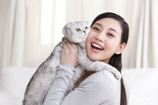 Young woman playing with a Scottish Fold cat