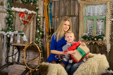 Boy with a mother sitting on Christmas sleigh