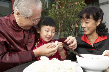 Family Making Dumplings In Courtyard