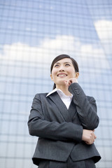 Young businesswoman standing in front of a tall building