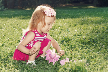 Girl with red hair playing with flowers in nature