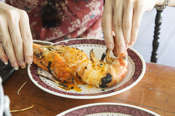 Hand of woman peeld Grilled big shrimps