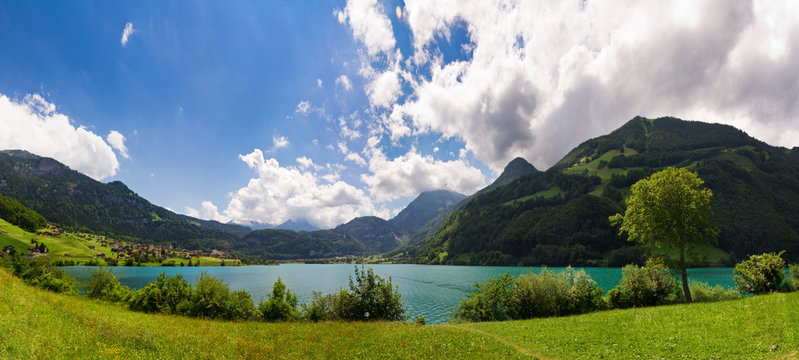 Panoramic image of a Green and Blue Mountain lake in the Swiss Alps