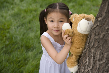 Young Girl Helping Her Teddy Bear Climb A Tree