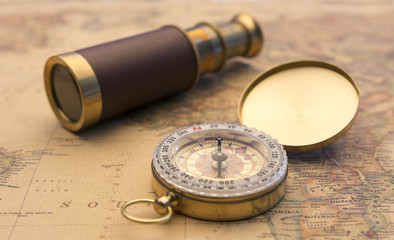 Fototapeta na wymiar Old compass and old telescope on vintage map world explorer concept