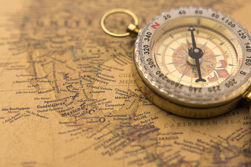 Old compass on vintage map selective focus on Mexico