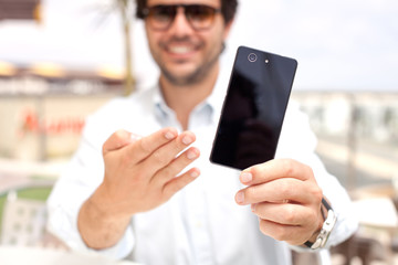 Young man showing a mobile phone
