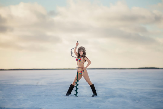 girl in bathing suit with ice screw on the ice