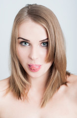 Fototapeta premium Beautiful woman model sticking tongue out as funny face concept