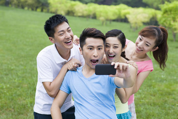 Cheerful young friends taking self portrait shot with smart phone