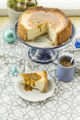 Coconut and lime cheesecake with passion fruit and caramel. Christmas decoration, hyacinth and blue plateau.