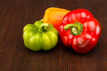 Different kinds of pepper on dark wooden surface