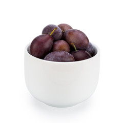 Plums in ceramic bowl - isolated on white background