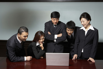 Five business professionals watching laptop
