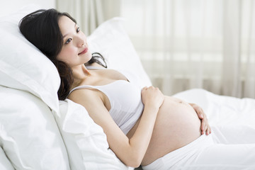 Obraz premium Pregnant woman resting in bed