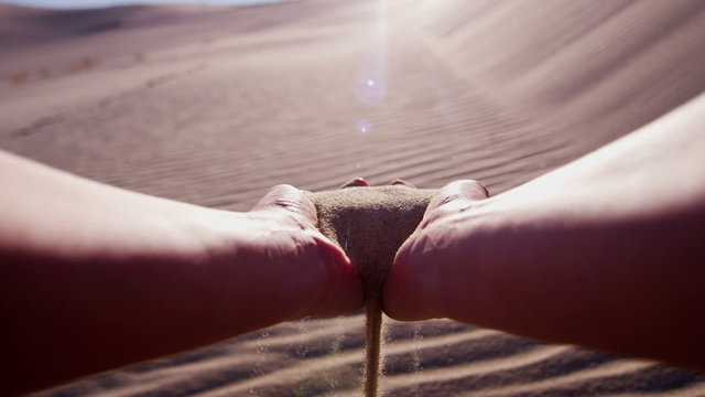 Sand desert hands sun flare grains hot Caucasian famine