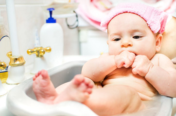 baby newborn takes bath sink basin pink towel head hands punch