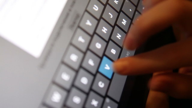 fingers typing on the tablet; close-up