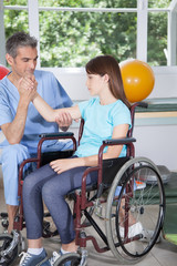 Male therapist with girl in wheelchair