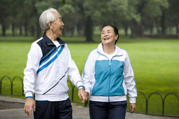 Senior Couple Walking Hand-In-Hand Through a Park