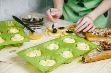 The woman in the kitchen cooking buns with poppy seeds