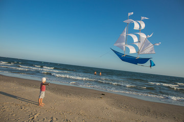 Kid starts a kite on the sea