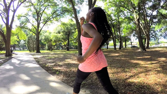 Young African American fitness girl power walking outdoor