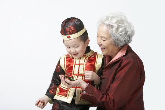 A grandmother shares candy with her grandson on Chinese New Year