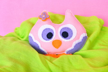 Felt owl - handmade felt colorful owl toy on pink and green background 
