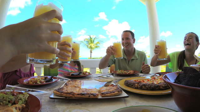 Young Caucasian family dining on vacation beach hotel decking