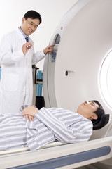 Medical professional helping a patient into a MRI scanner