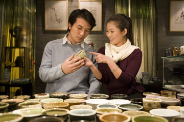 Young Couple Looking At Objects In Shop