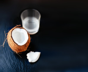Cracked coconut  with Coconut Milk in a Glass. Coco nut cut in h