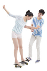 Fototapeta premium Young man teaching his girlfriend to skateboard