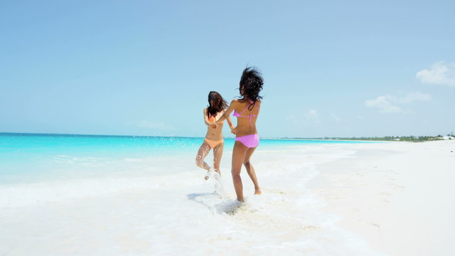 Laughing multi ethnic girls enjoying tropical beach