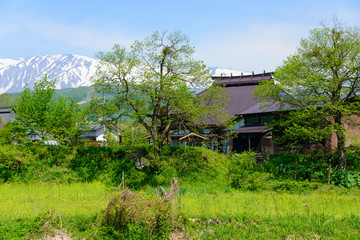 Shirouma mountains and old houses at Ooide park in Hakuba, Nagano, Japan