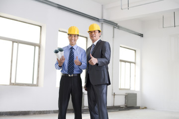 Excited businessmen giving thumbs up