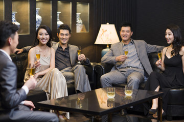 Cheerful adults drinking alcohol in luxury club