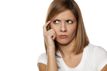 Fototapeta premium frowning young woman thinking on white background
