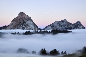Fototapeta na wymiar Morgendämmerung, Grosser und kleiner Mythen, Schweizer Berge, Wald und Nebelmeer