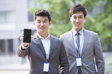 Young business person showing smart phone