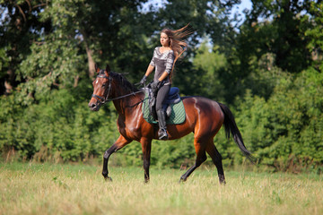 Young woman riding Trakehner horse 
